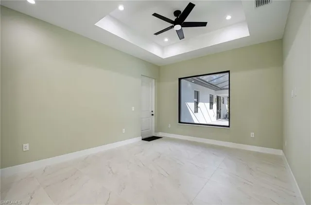 an empty room with a ceiling fan and window