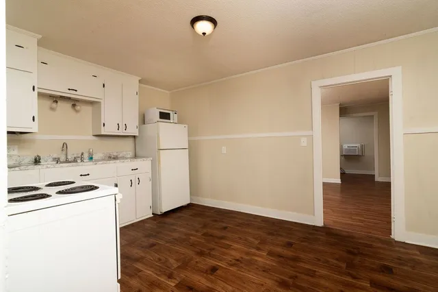 a kitchen with granite countertop a refrigerator and a stove top oven