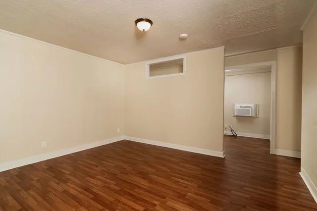 a view of an empty room with wooden floor