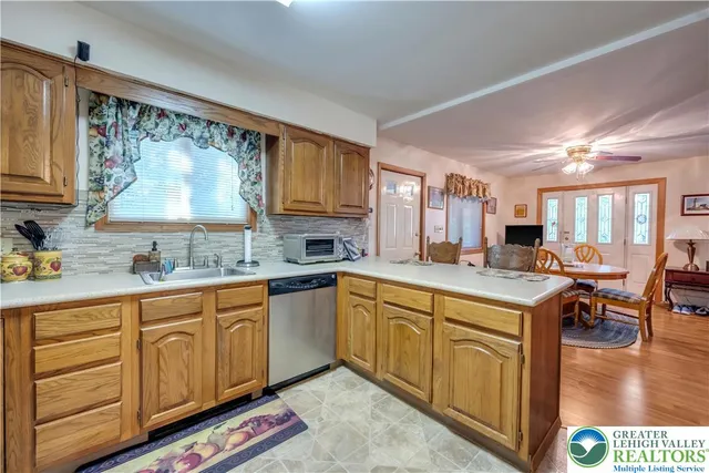 a kitchen with stainless steel appliances granite countertop a sink cabinets and wooden floor