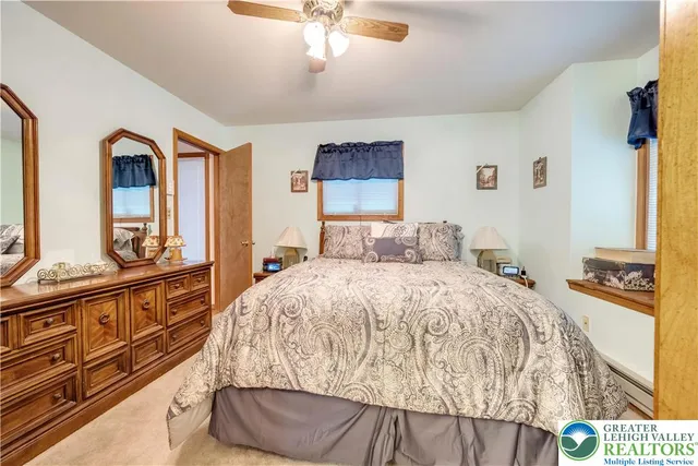 a spacious bedroom with a bed and a dresser with mirror