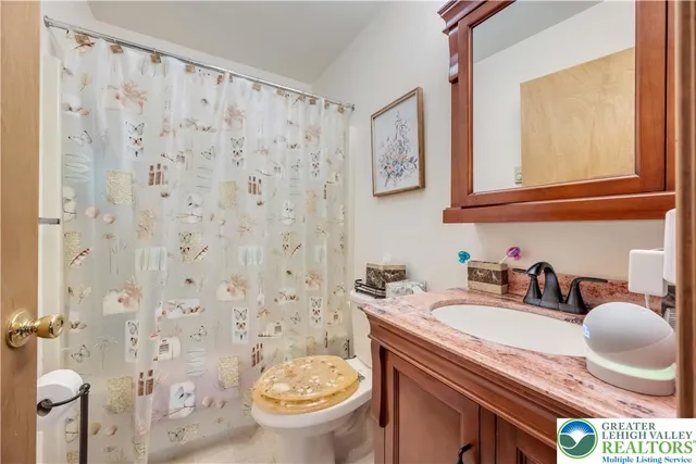 a bathroom with a granite countertop sink a toilet and a mirror