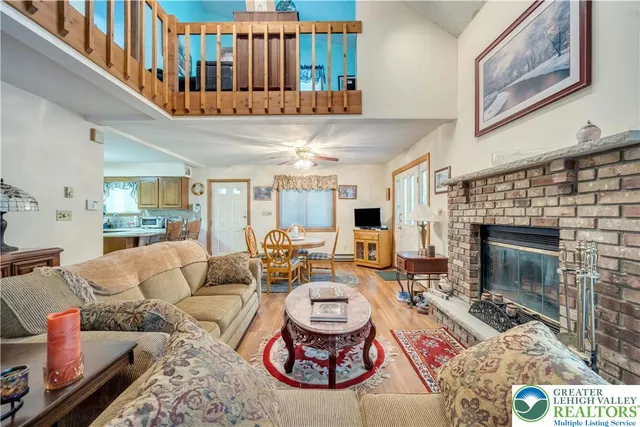 a living room with furniture a fireplace and a large window