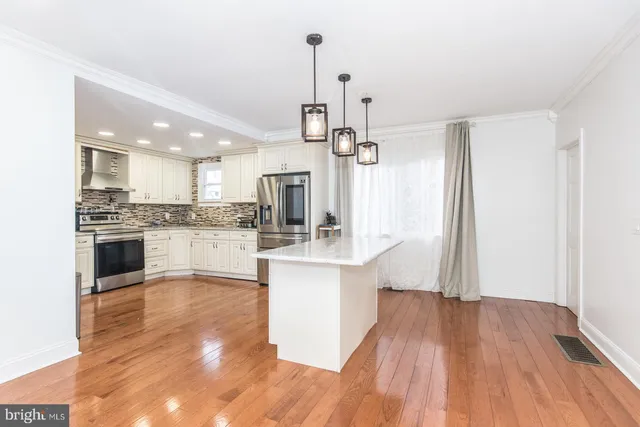 a large kitchen with kitchen island a sink stainless steel appliances and cabinets