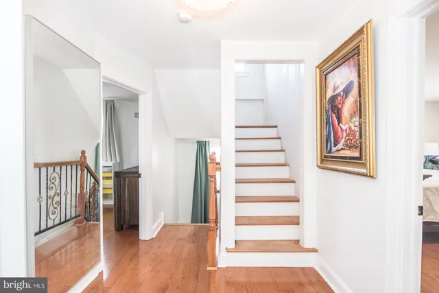 a view of a hallway with entryway and wooden floor