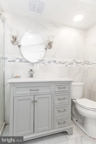 a bathroom with a sink a toilet and a mirror