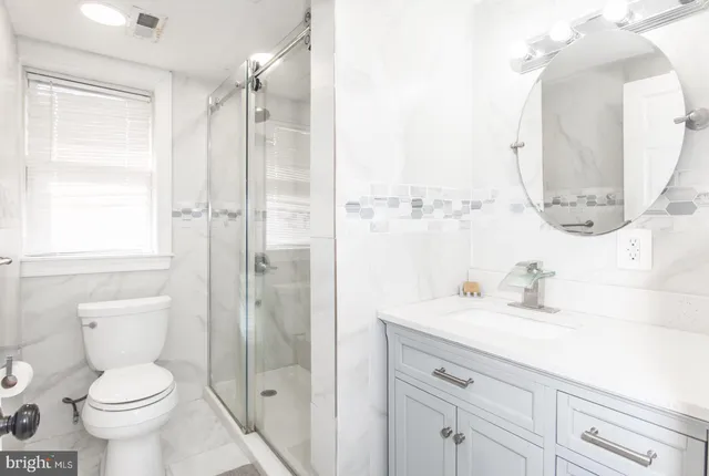 a bathroom with a sink a toilet and shower