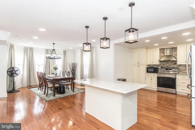 a kitchen with stainless steel appliances kitchen island granite countertop a kitchen island a stove a table and chairs