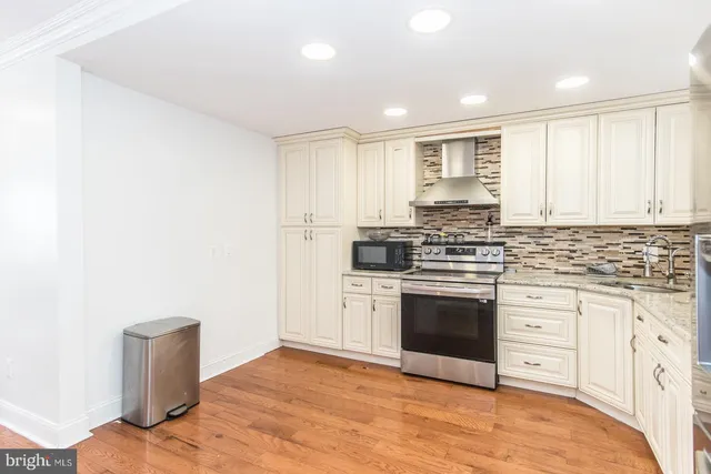 a kitchen with granite countertop white cabinets and stainless steel appliances