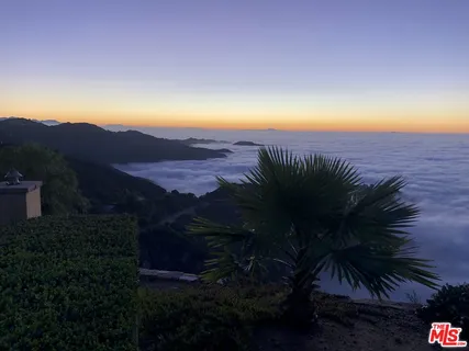 a kitchen with stainless steel appliances kitchen island granite countertop a table and chairs in it