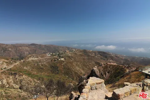 a view of a yard with wooden fence