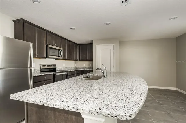 a kitchen with kitchen island sink refrigerator and stove
