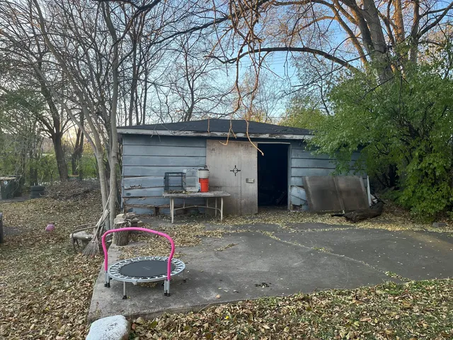 a view of a chair and table in backyard of the house