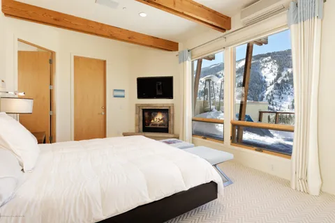 a bedroom with a bed and a large window with balcony view
