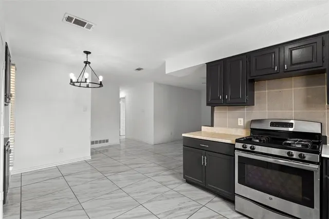 a kitchen with stainless steel appliances granite countertop a stove a sink and a refrigerator