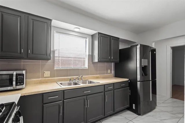 a kitchen with stainless steel appliances granite countertop a refrigerator and a sink