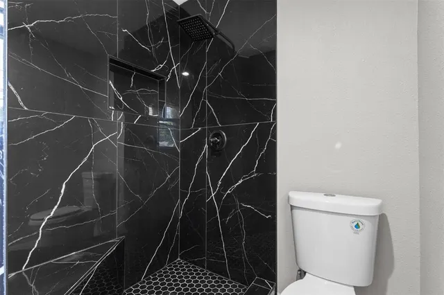 a bathroom with a toilet and a shower