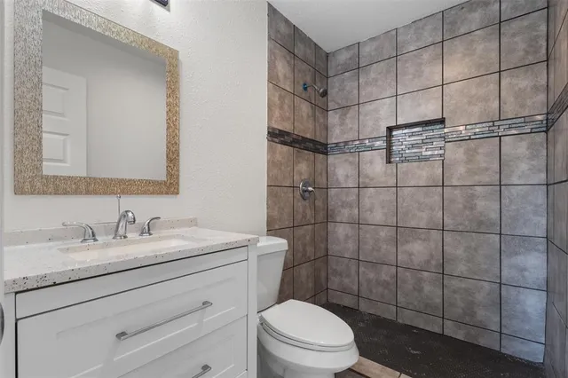 a bathroom with a toilet sink vanity and shower