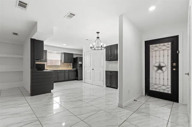 a large white kitchen with kitchen island granite countertop a refrigerator and a sink