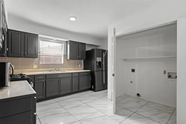 a kitchen with stainless steel appliances granite countertop a refrigerator and a sink