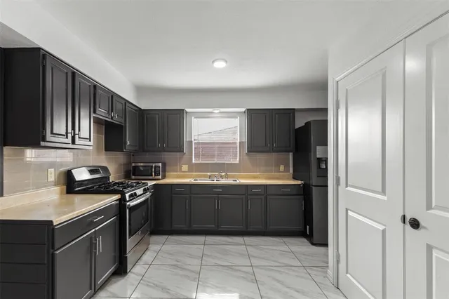 a kitchen with stainless steel appliances granite countertop a sink and a stove
