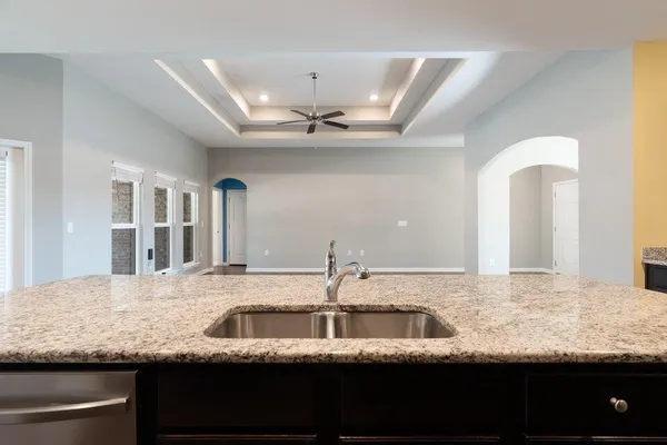 a kitchen with granite countertop a sink and a wooden floor