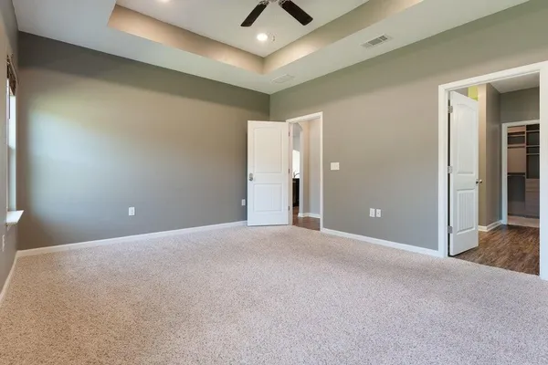 a view of an empty room and chandelier fan
