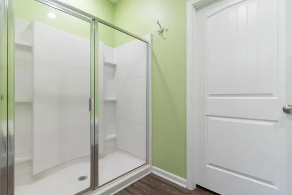 a bathroom with a shower and a glass door