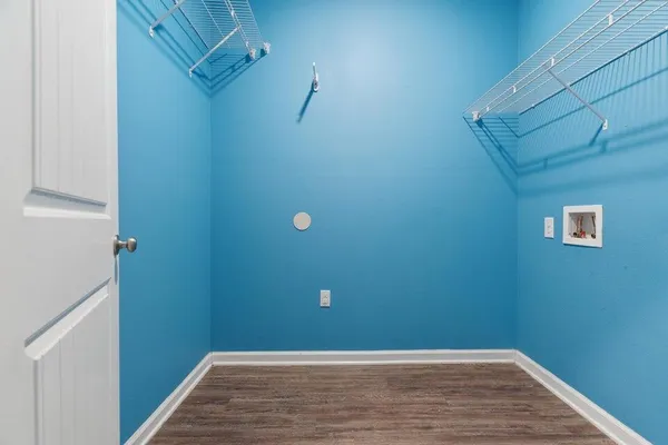 a view of a small space with wooden floor and mirror