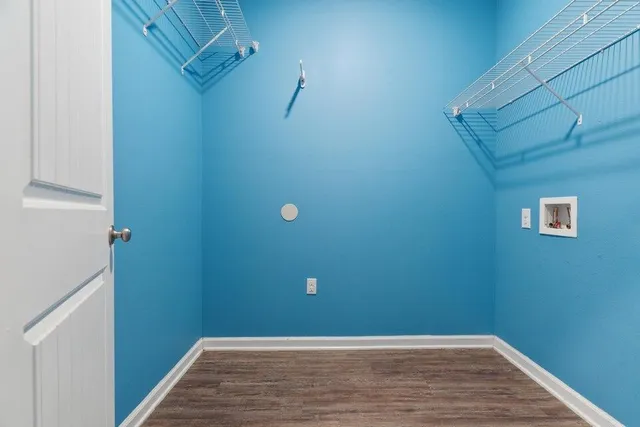 a view of a small space with wooden floor and mirror