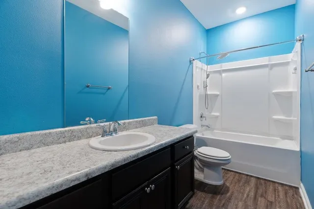 an empty room with a chandelier fan and windows