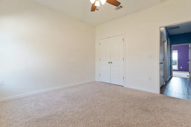 a bathroom with a granite countertop toilet sink and mirror