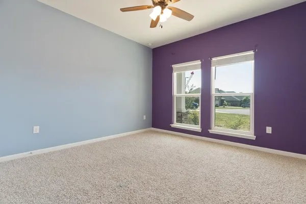 a view of an empty room and a ceiling fan