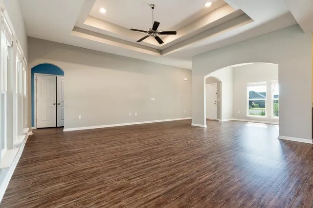 a view of a room with wooden floor and a ceiling fan