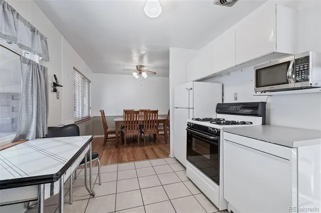 a kitchen with a stove a table and chairs in it