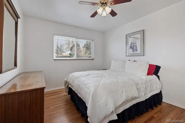 a bedroom with bed and wooden floor