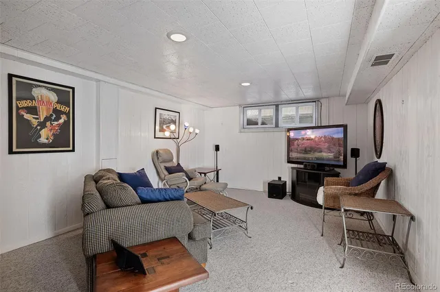a living room with furniture a rug and a flat screen tv
