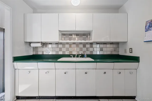 a view of kitchen with granite countertop white cabinets and white appliances