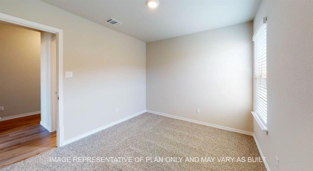 10113 Neptune Court Waco, TX 76708 - Photo 21 of 24 Neutral tone wall paint, textured carpet flooring, window with blinds, wood-finish flooring visible through doorway, ceiling-mounted light fixture