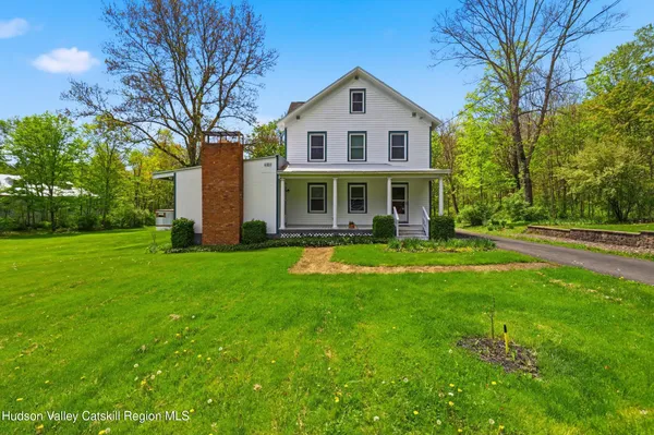 a front view of a house with yard and green space