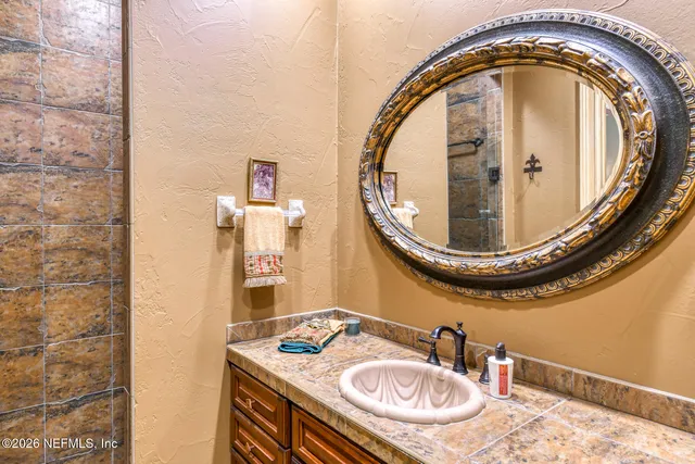 a bathroom with a sink mirror and a toilet