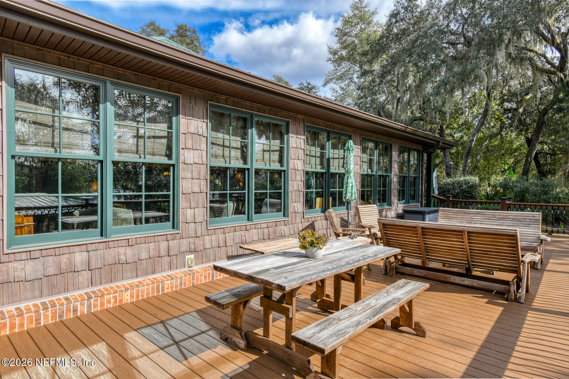 131 Whitney Street Satsuma, FL 32189 - Photo 38 of 75 a view of a patio with dining table and chairs with wooden floor and fence