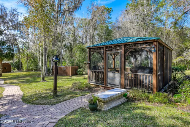 a view of a chair and table in backyard of the house