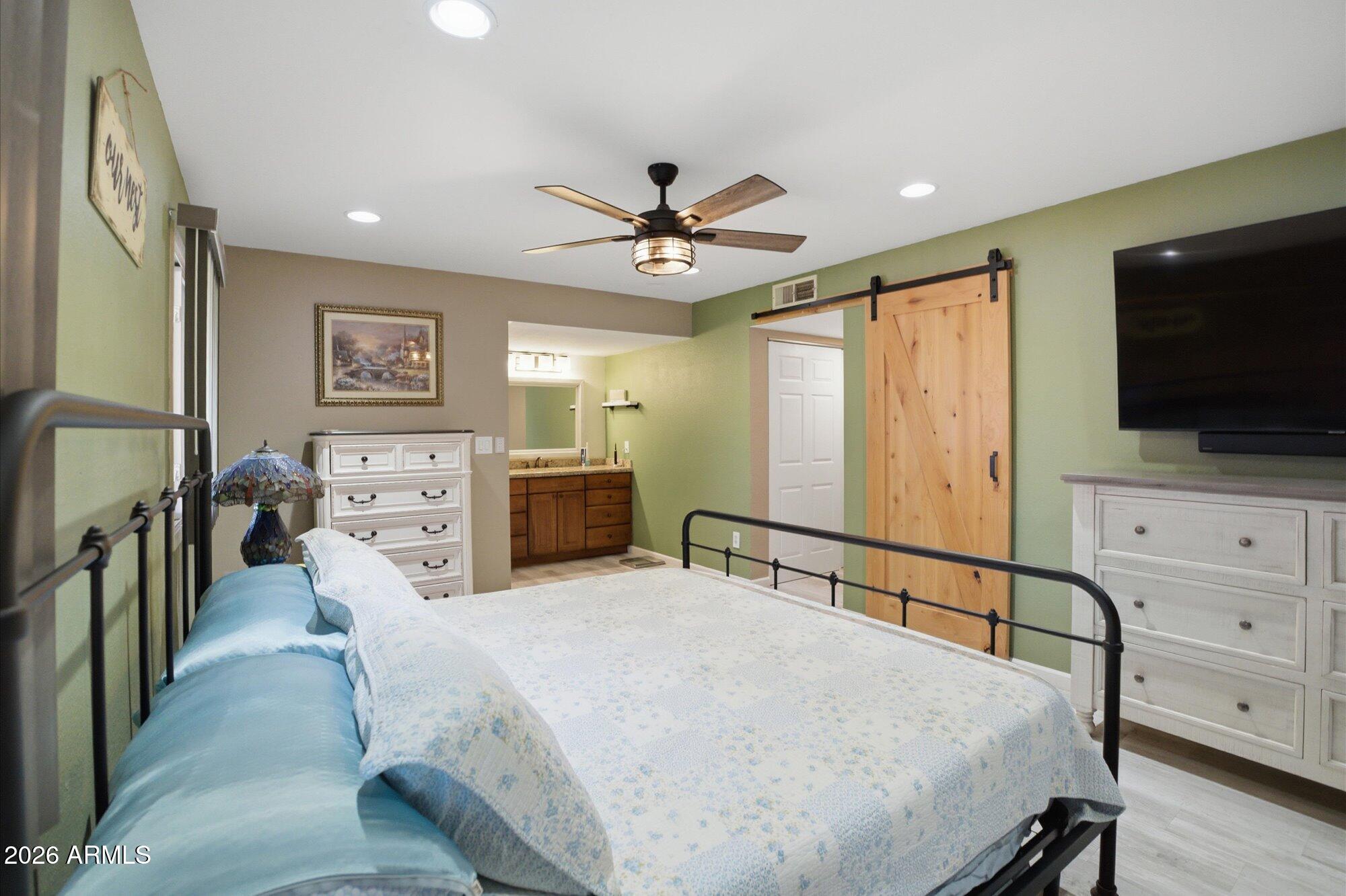 2222 West Maple Drive Phoenix, AZ 85027 - Photo 10 of 32 a spacious bedroom with a bed a flat screen tv and dresser