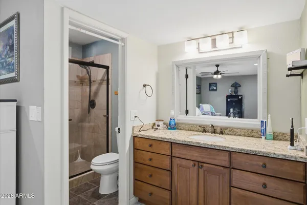 a bedroom with a bed next to a window with a flat screen tv