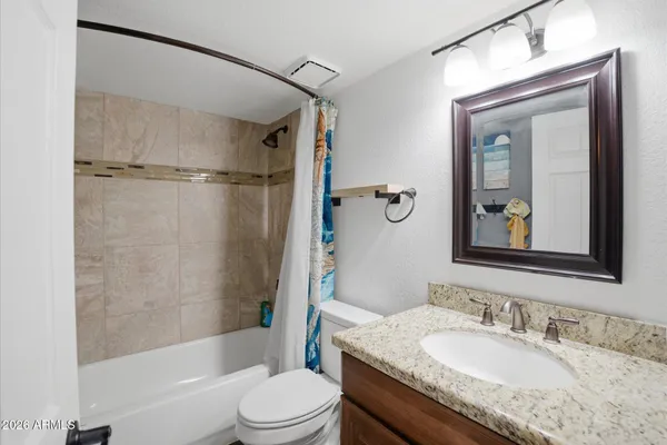 a bathroom with a granite countertop sink toilet a large mirror a vanity and shower