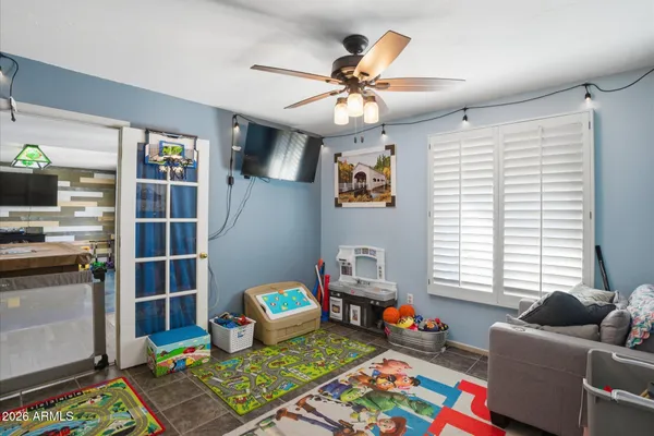 a living room with baby crib furniture and a window
