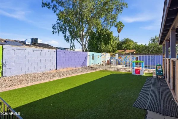 a view of a deck with a big yard potted plants and large tree