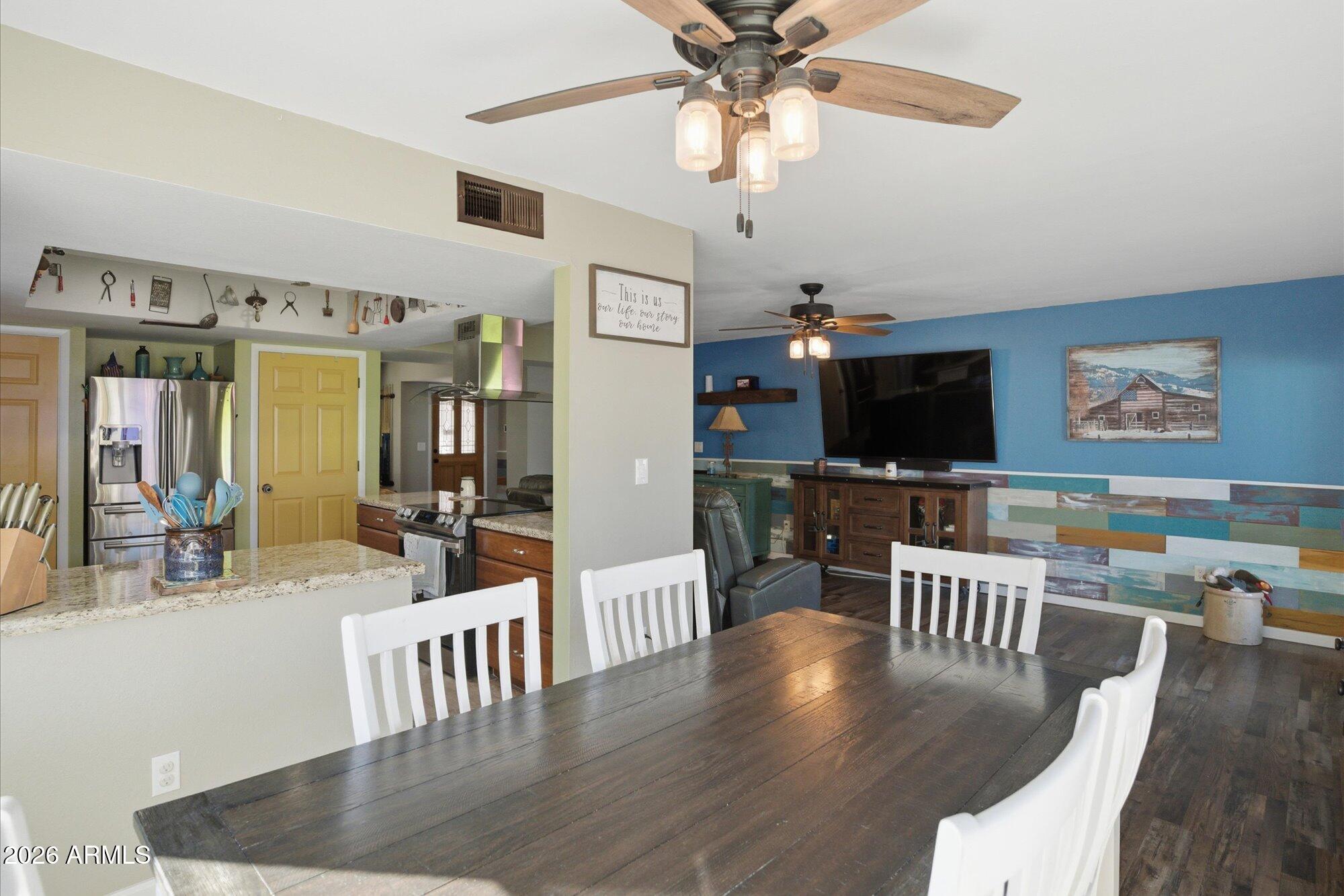 2222 West Maple Drive Phoenix, AZ 85027 - Photo 6 of 32 a view of a dining room with furniture a chandelier and wooden floor