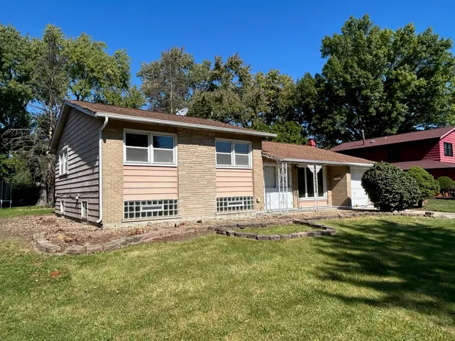 a house with green field in front of it
